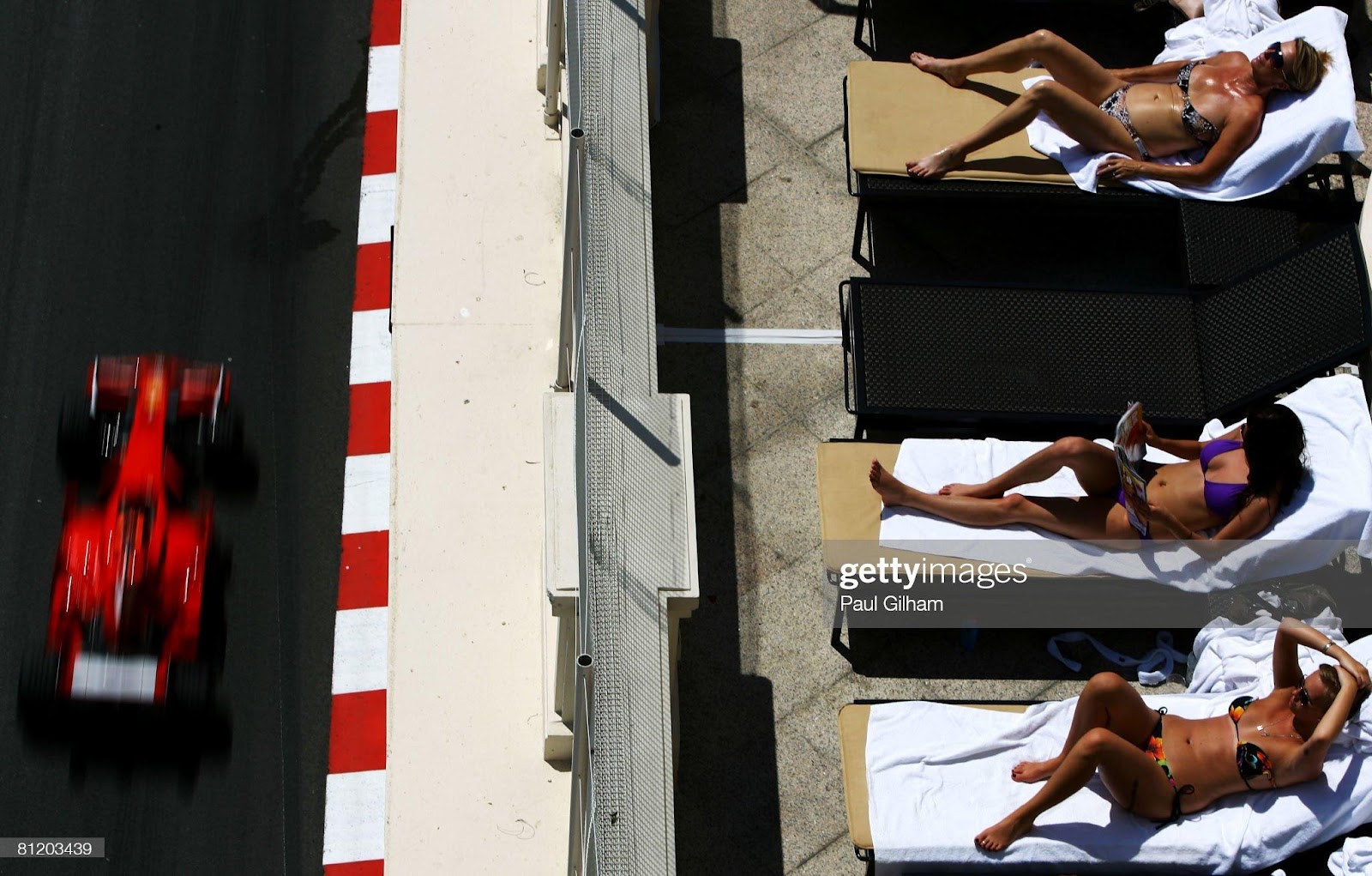 Sunbathers relax as Kimi Raikkonen, Ferrari, drives by during practice for the Monaco F1 Grand Prix at the Monte Carlo Circuit on May 22, 2008.
