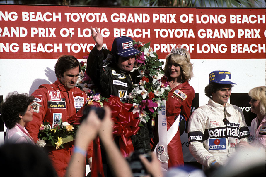 Jones celebrates victory on the podium but Reutemann cuts a frustrated figure. At the next race in Brazil, Reutemann again led but this time refused to give way to Jones before taking a controversial win.  Nelson Piquet celebrates his 3rd place at the Long Beach GP, the 1981 season opener.