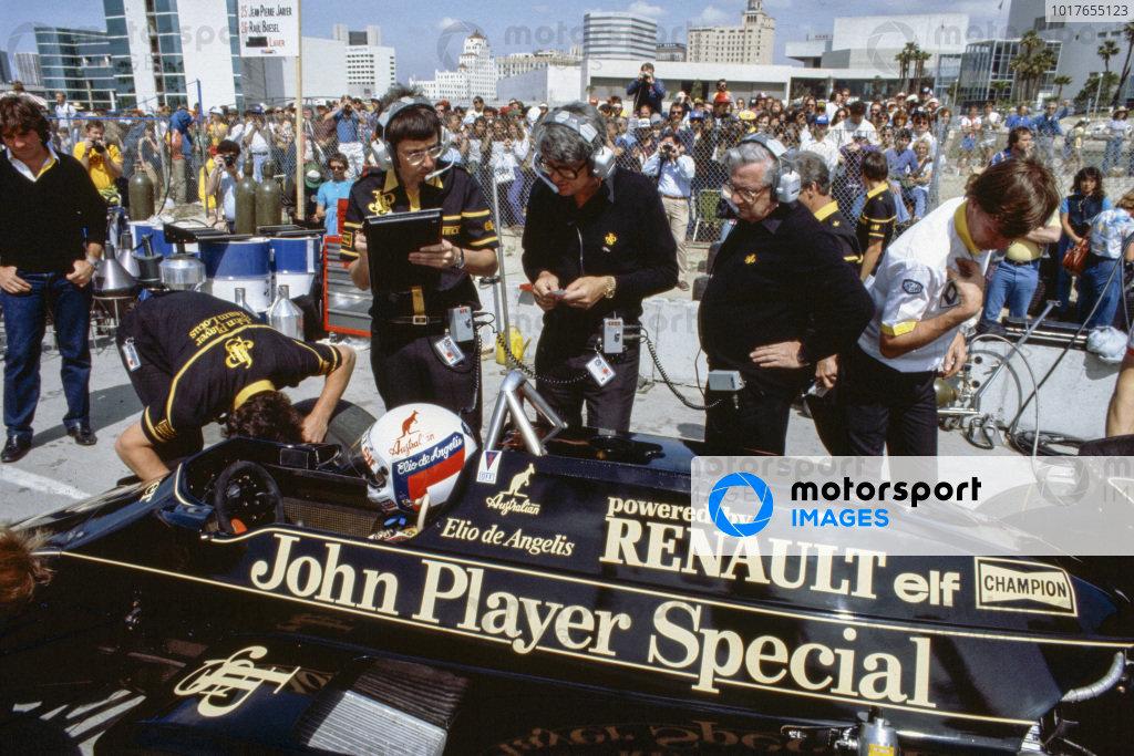 1983 Elio de Angelis, Lotus 93T Renault, in the pit lane. Tony Rudd and Peter Warr work to the right of the car.