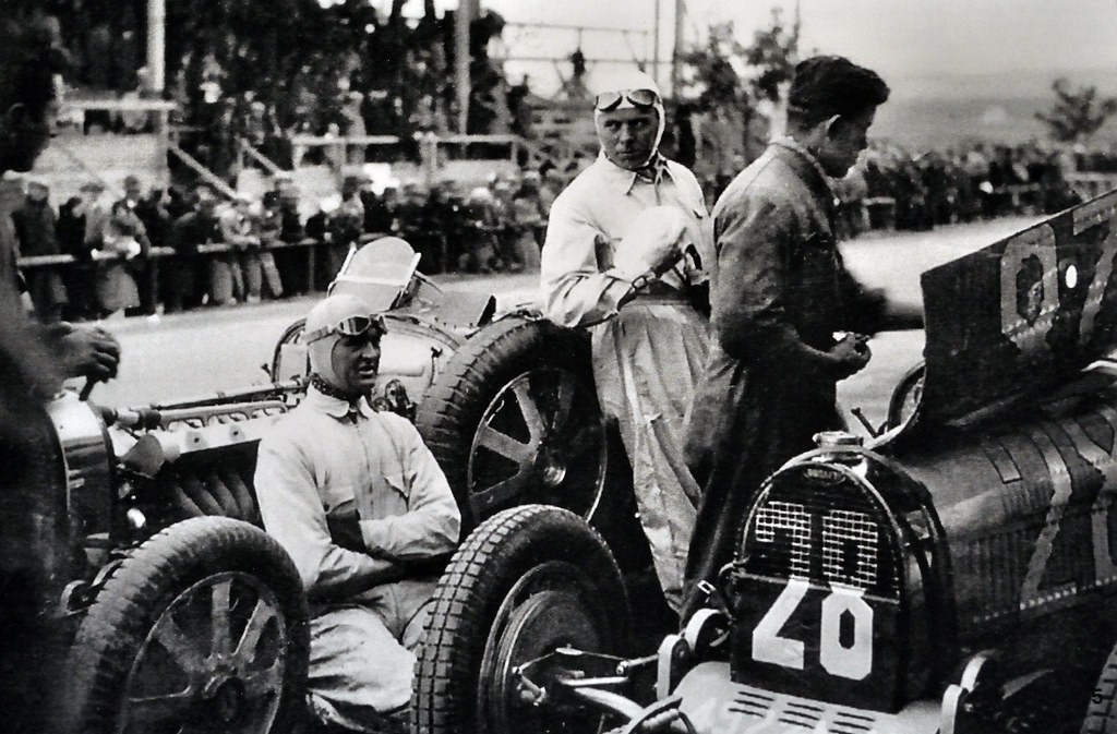 Louis Chiron warming himself on the engine of Varzi´s Bugatti in 1931.