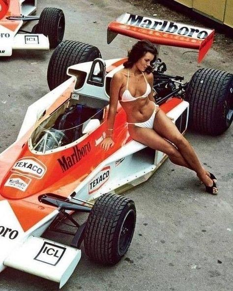 A girl in a white bikini on a McLaren F1.