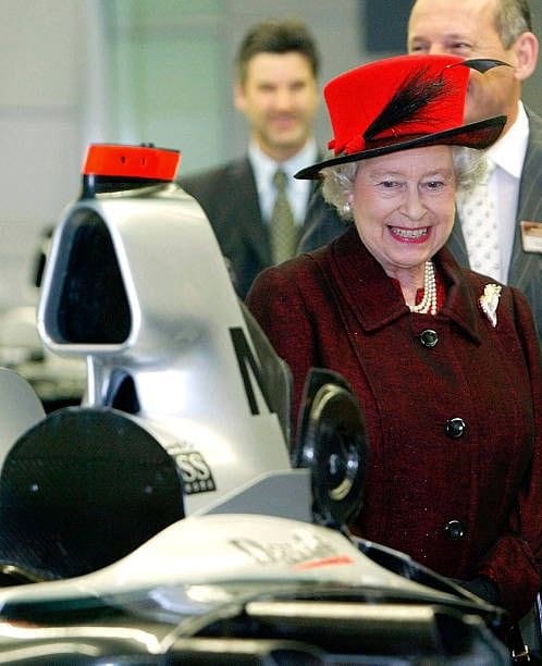 Queen Elizabeth II looks at the McLaren Formula 1 car that belongs to David Coulthard, during her tour of McLaren in Woking, England, May 12, 2004.