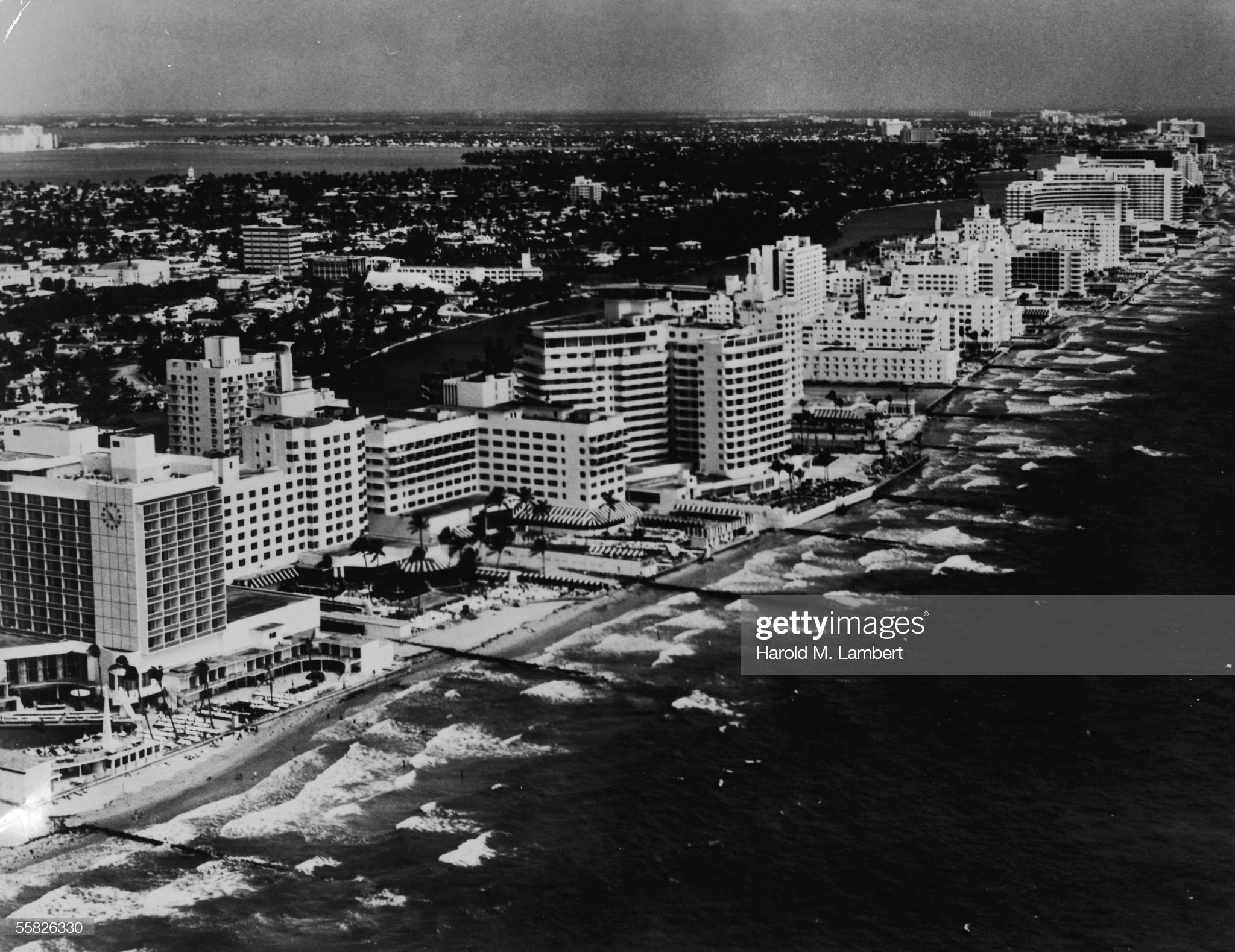 Aerial view looking North which shows the oceanfront luxury resort hotels of Miami Beach, Florida, 1950s or 1960s. Prominent buildings include the Seville, Sea Isle, San Souci, Saxony, Robert Richter and Versailles Hotels. 