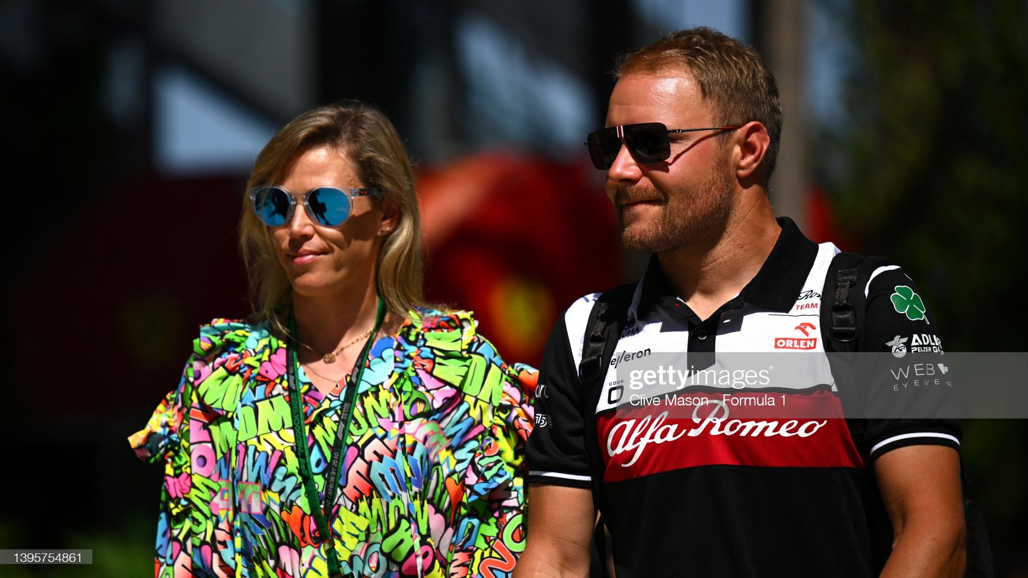 Valtteri Bottas of Finland and Alfa Romeo F1 and his girlfriend cyclist Tiffany Cromwell walk in the Paddock prior to practice ahead of the F1 Grand Prix of Miami at the Miami International Autodrome on May 06, 2022 in Miami, Florida. 