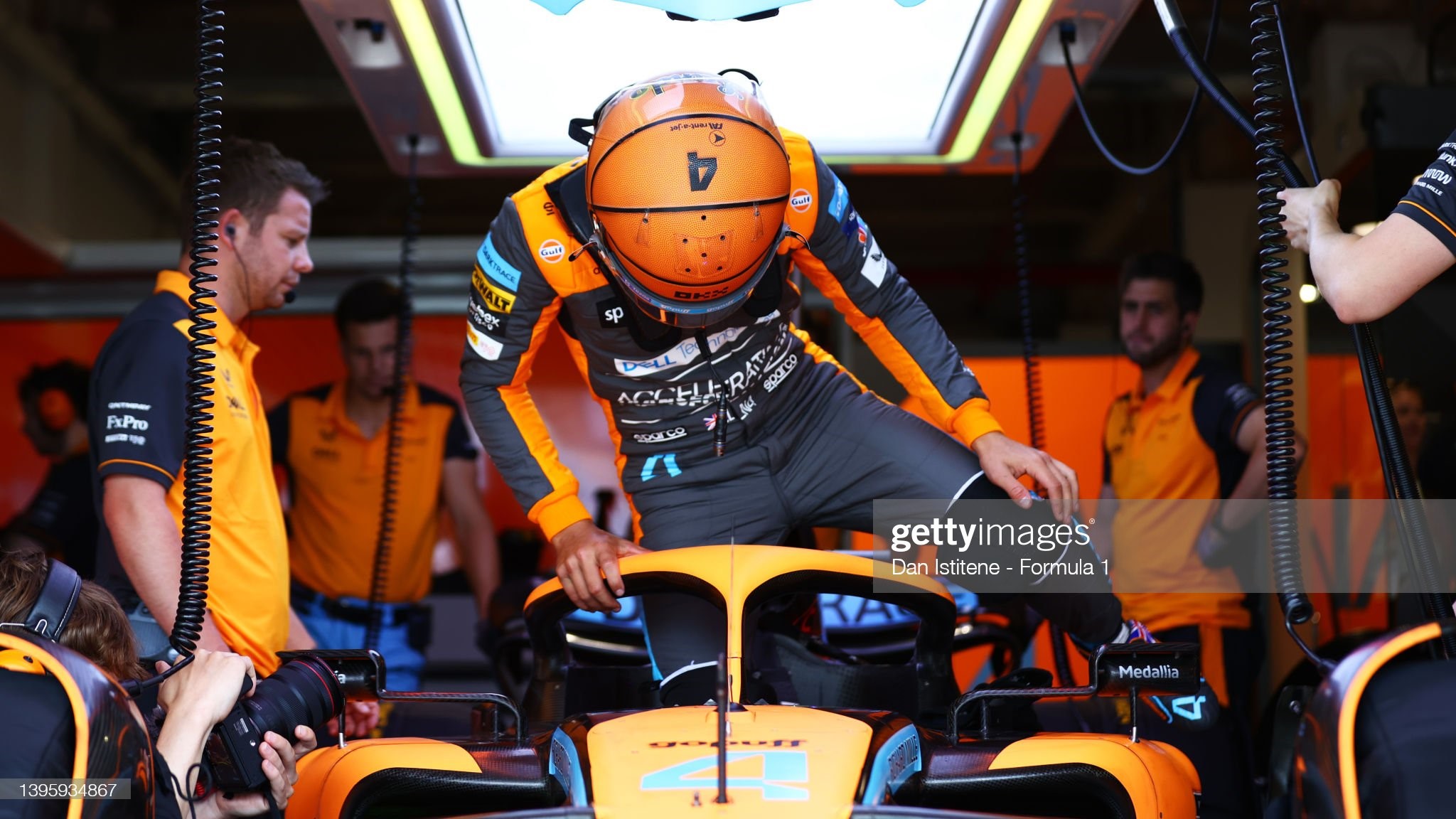 Lando Norris of Great Britain and McLaren prepares to drive in the garage during final practice ahead of the F1 Grand Prix of Miami at the Miami International Autodrome on May 07, 2022 in Miami, Florida. Norris wears an helmet with a basketball design. 