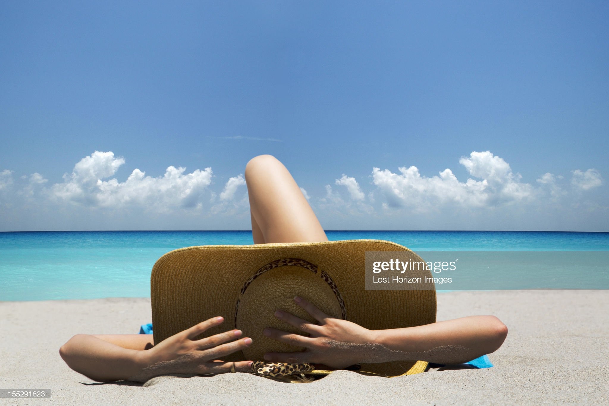 Woman laying on towel on beach.