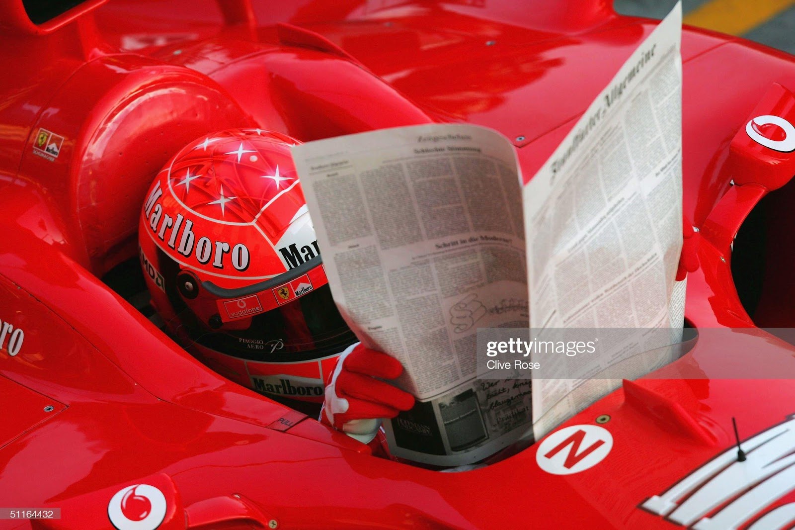 Michael Schumacher, Ferrari, poses with a newspaper in the pits prior to the practice session for the Hungarian F1 Grand Prix at the Hungaroring Circuit on August 13, 2004, in Budapest, Hungary.