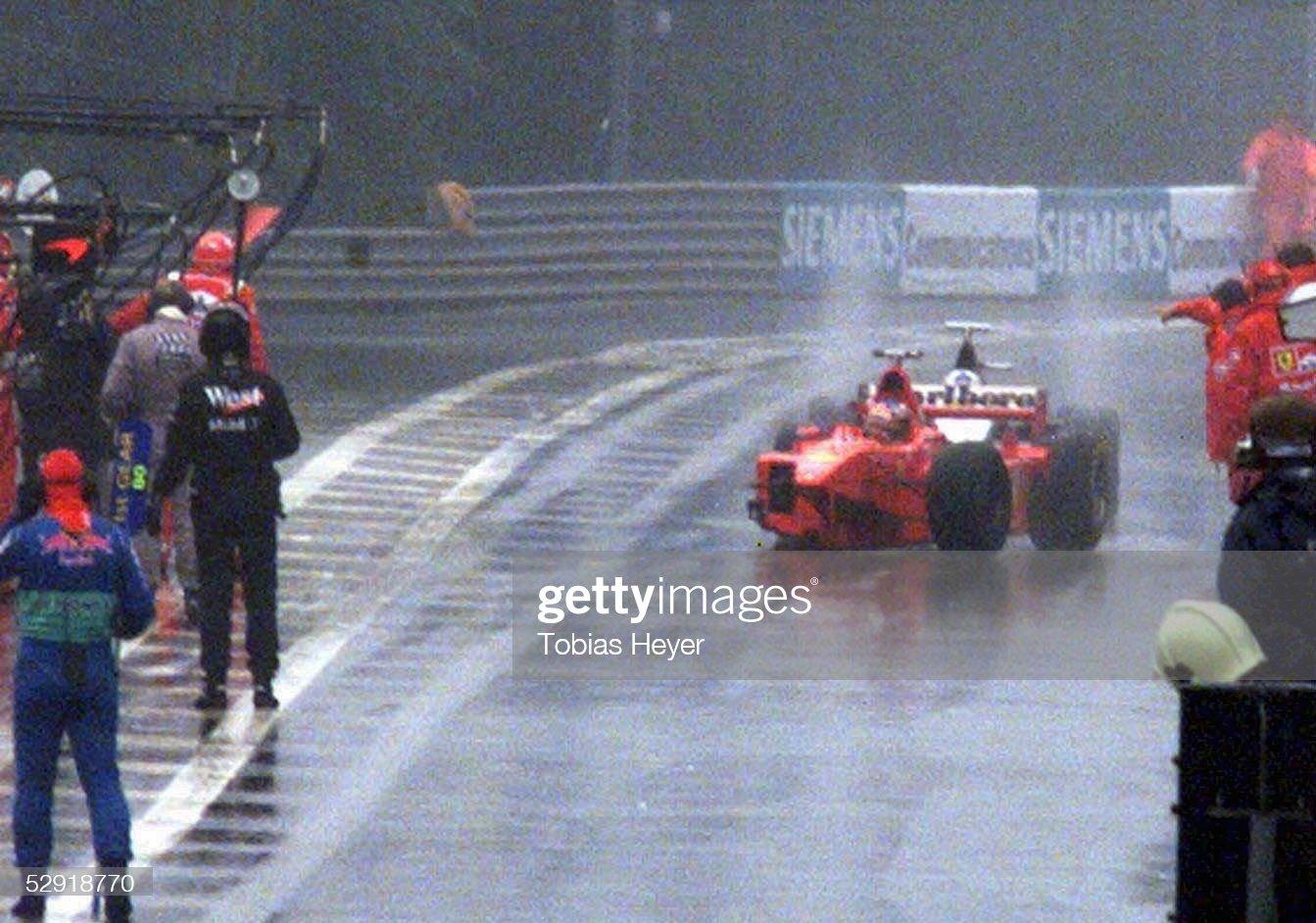 Michael Schumacher drives into the pits on three wheels in front of David Coulthard at the 1998 Belgian Grand Prix in Spa-Francorchamps.
