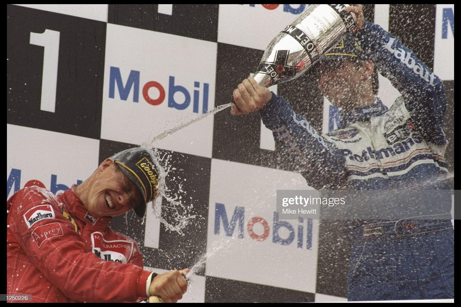 5 Apr 1996: Damon Hill celebrates his win of the San Marino Grand Prix in Imola by spraying rival Michael Schumacher with champagne. 
