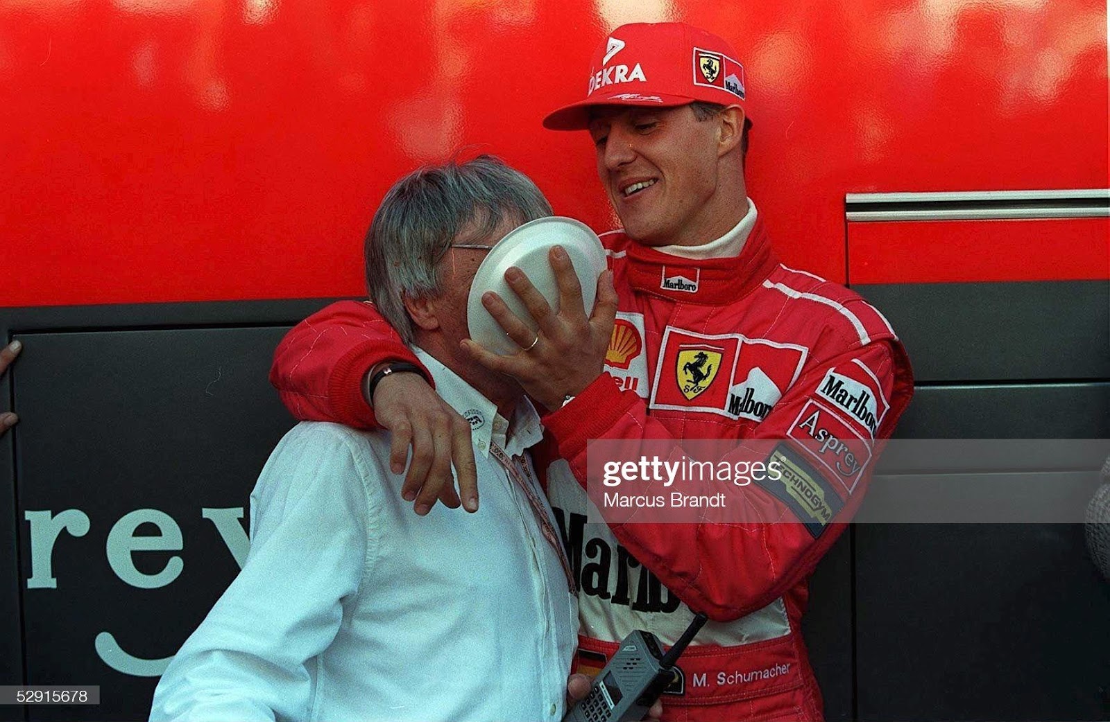 Michael Schumacher smears a cake on Bernie Ecclestone's face.