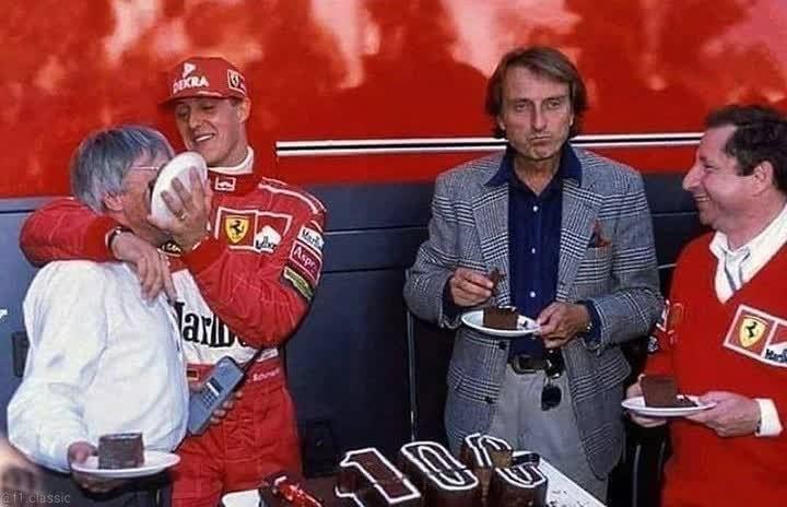 Michael Schumacher smears a cake on Bernie Ecclestone's face in front of Luca di Montezemolo and Jean Todt..