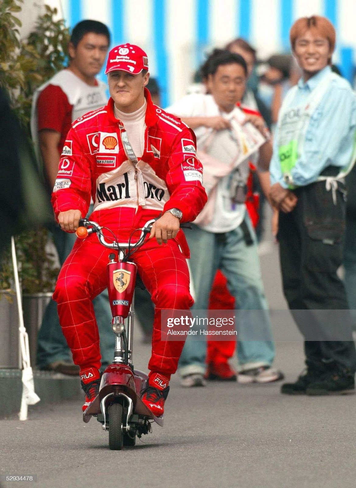 2003 Japanese Grand Prix, Suzuka. Michael Schumacher, Ferrari, drives through the pits on a scooter. 