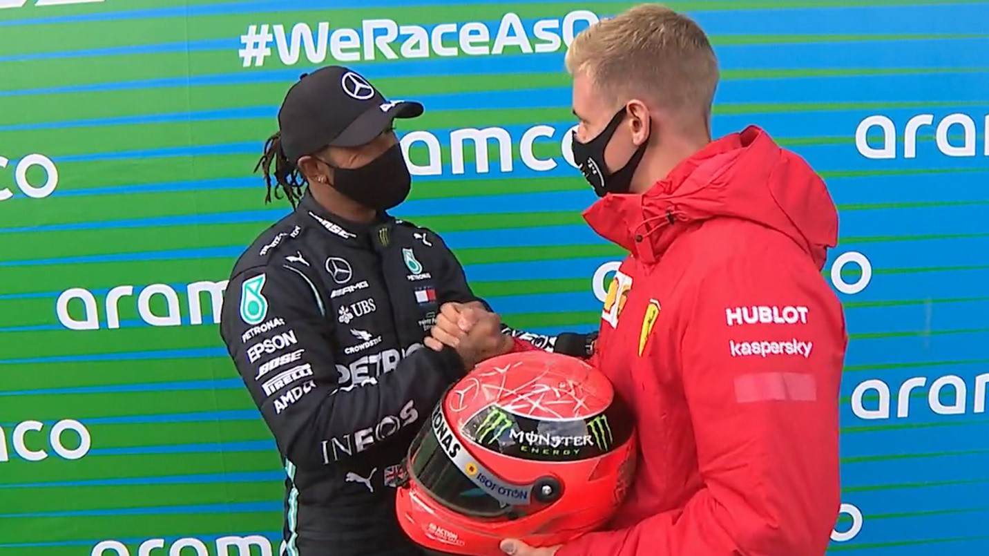 Mick Schumacher presents Hamilton with one of his father's helmets as Brit equals Michael's win tally.