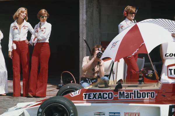 26-28th April 1974, Spanish Grand Prix, Jarama, Madrid, Spain. Emerson Fittipaldi, McLaren M23 Ford, keeps cool in the cockpit while being filmed as two Marlboro girls look on. 