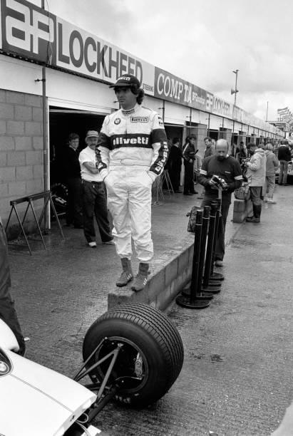 Nelson Piquet, driving for Brabham-BMW, stands on a wall in the pit lane as drivers compete in a qualifying session for the 1985 British Grand Prix at the Silverstone Circuit, near Towcester, Northamptonshire, U.K., on Saturday, July 20, 1985.