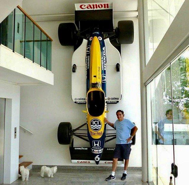 Nelson Piquet with his 1987 championship-winning Williams FW11B hanging on the wall of his home in Brasilia.