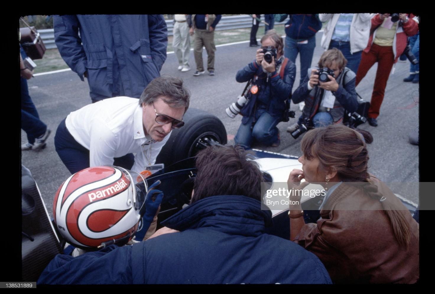 Bernie Ecclestone, owner of the Brabham Grand Prix team, left, talks with Nelson Piquet as he sits in his car on the starting grid for the Dutch Grand Prix as Piquets wife, Sylvia Piquet, right, looks on at the Zandvoort circuit in the Netherlands, on Sunday, August 28, 1983. 