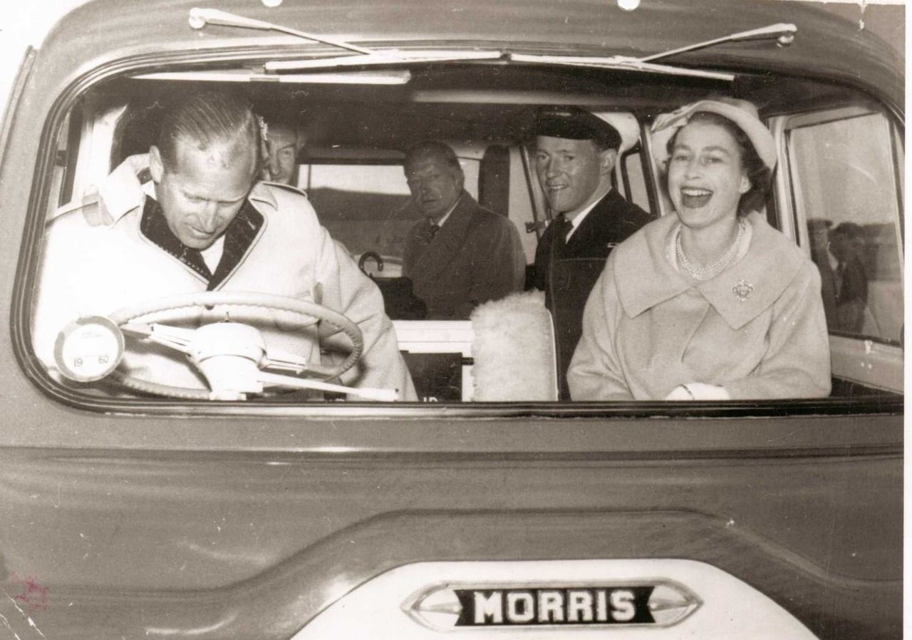 Queen Elizabeth laughing at Philip's attempts to drive a minibus in Orkney.