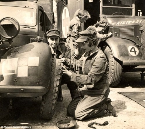 Taken at the Mechanical Transport Training Section, Camberley, Surrey, Princess Elizabeth in overalls changes a tire on a military Tilly truck. March 1945.