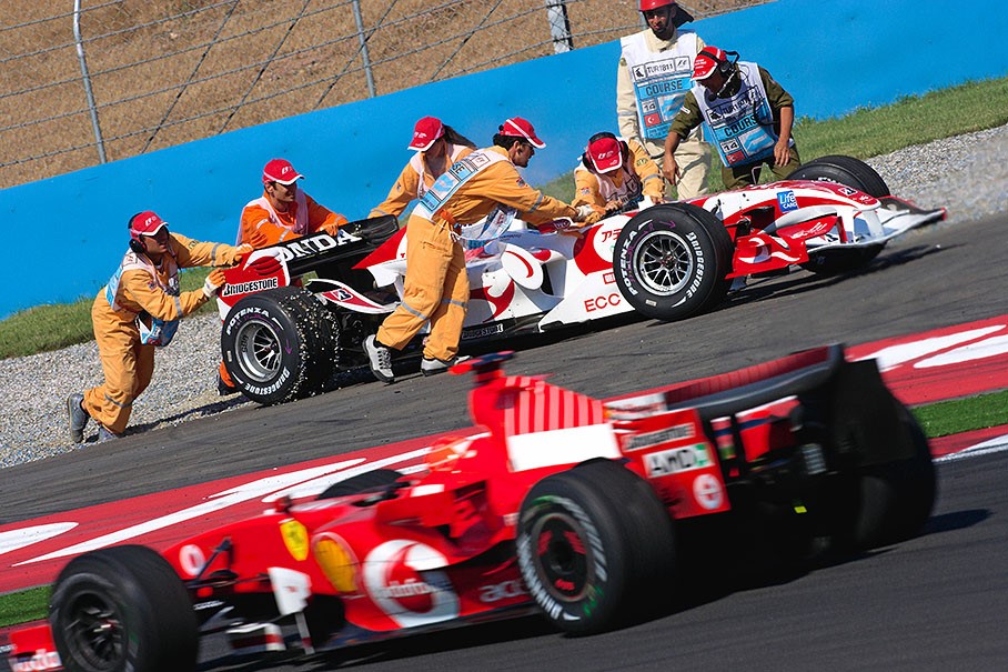 Sakon Yamamoto's Honda being pushed out of the gravel by helpful Turkish hands at Istanbul in 2006. 