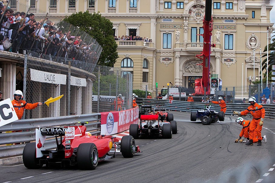 The field navigates around the remains of Rubens Barrichello's Williams car at Massenet turn at the Monaco GP in June 2010. 
