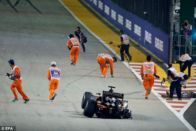 2016 Singapore GP. Marshalls recover debris from the crash under safety car conditions before the car is cleared.