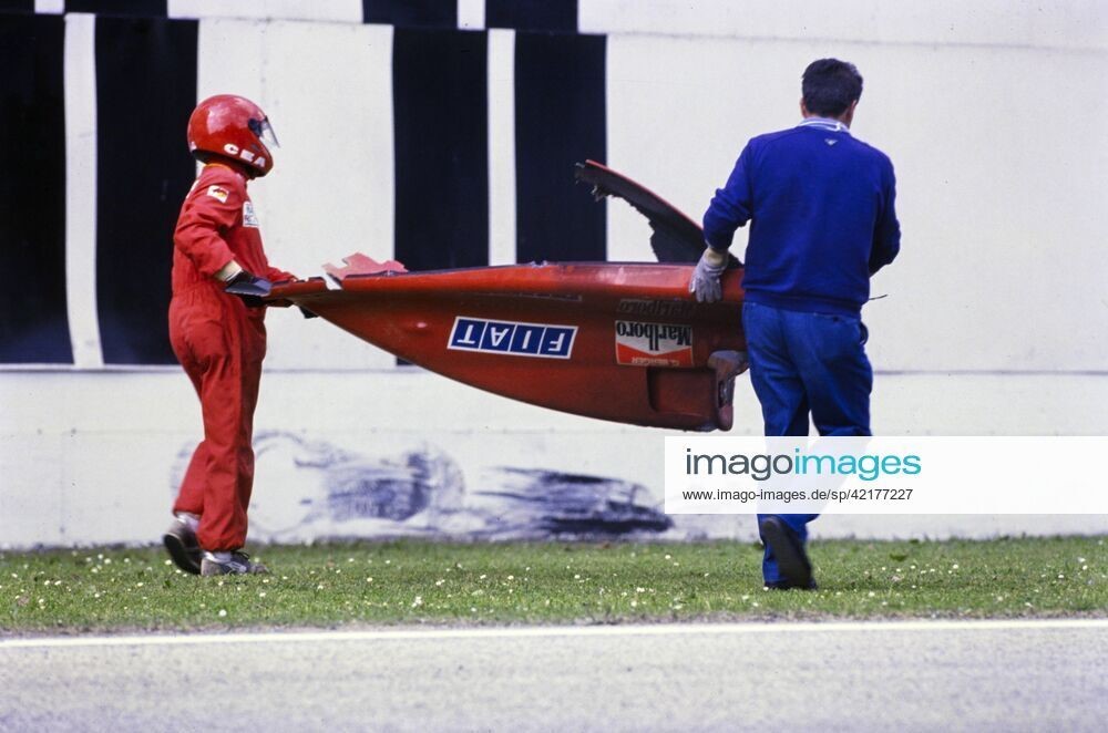 Marshals carry away the rear bodywork of Gerhard Berger s Ferrari 640 after a crash during the San Marino GP at Imola, Italy, on April 23, 1989.