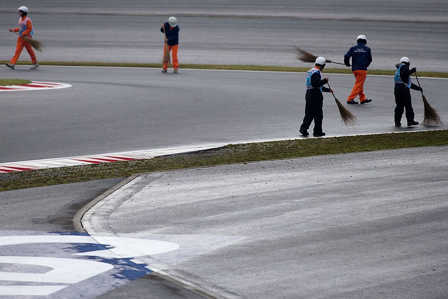 Between the sessions, marshals clean the track from rubber and dirt at Mount Fuji in 2008. 