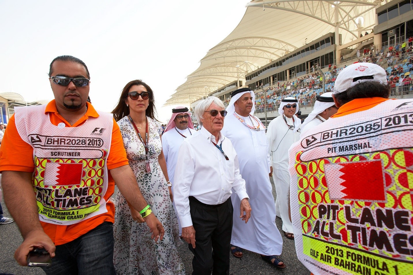 Formula One group CEO Bernie Ecclestone walks the grid with his wife Fabiana Flosi and the Bahrainian rulers at Sakhir, Bahrain, in 2013. 