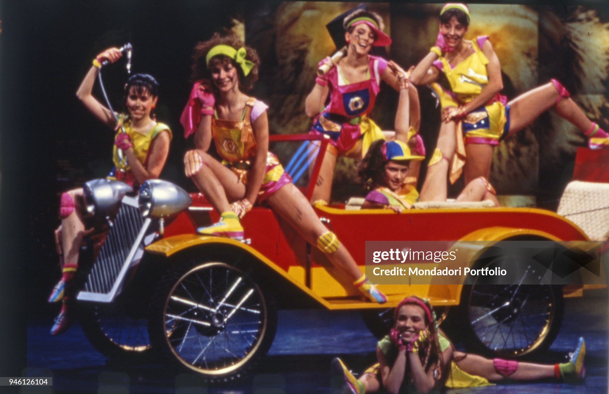Some dancers posing on a car on the set of the famous TV comic show 'Drive In', broadcasted by Italia 1, in Milan, Italy, in 1984. 