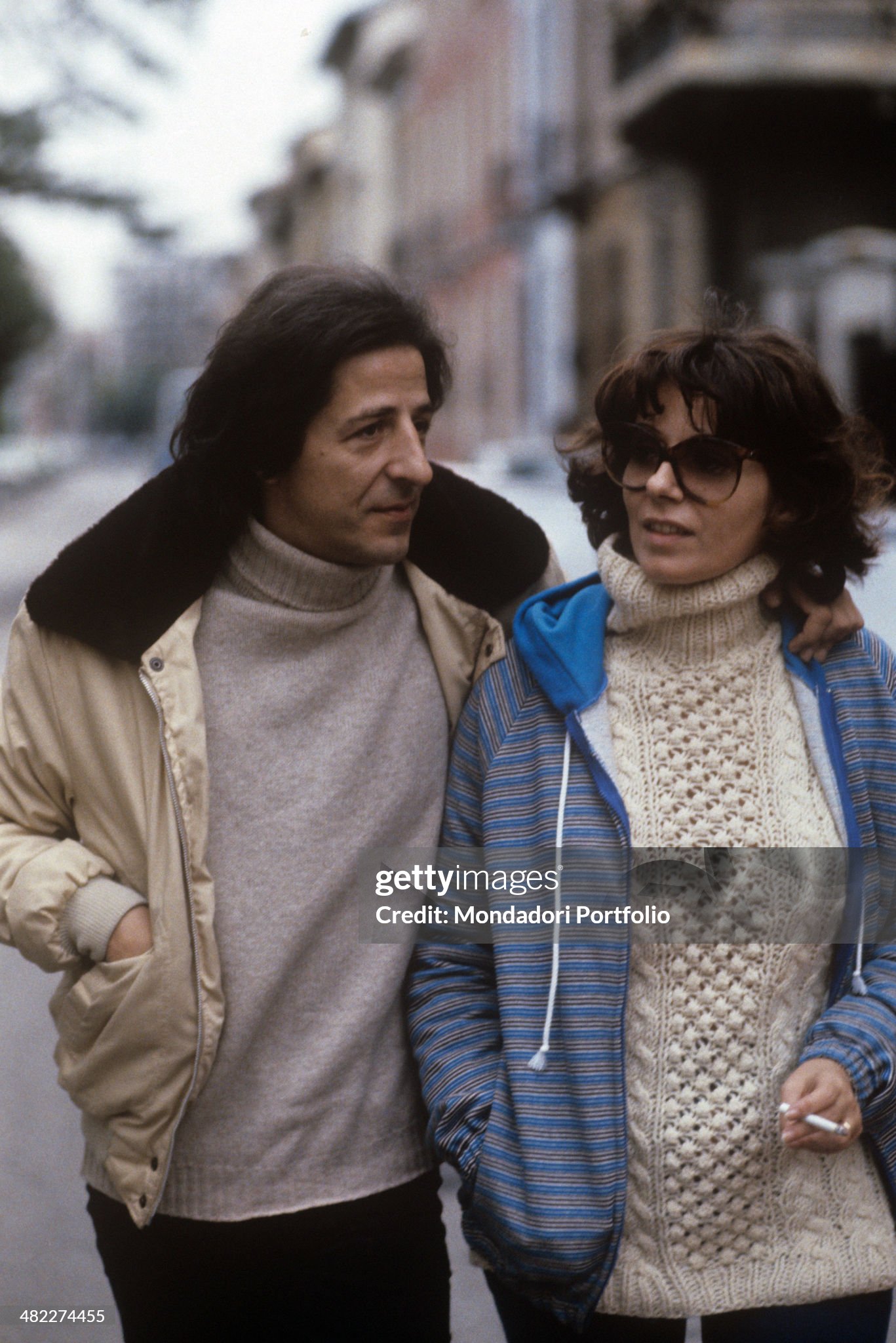 Giorgio Gaber walking in the streets of Milan with his wife and Italian singer, actress and politician Ombretta Colli in 1980. 