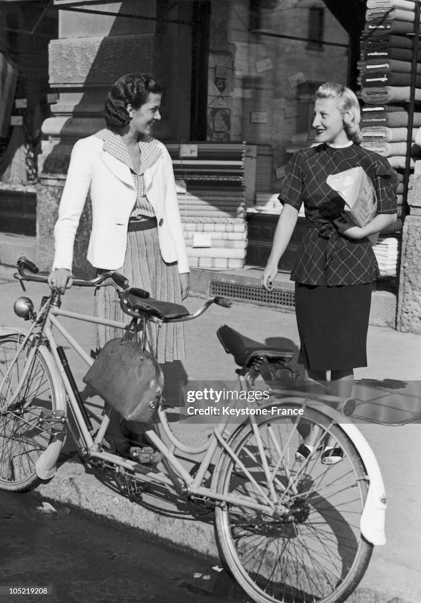 Women standing beside their bicycles in a street of Milan around 1945-1950. In post-war Italy, gas was a rare commodity. 