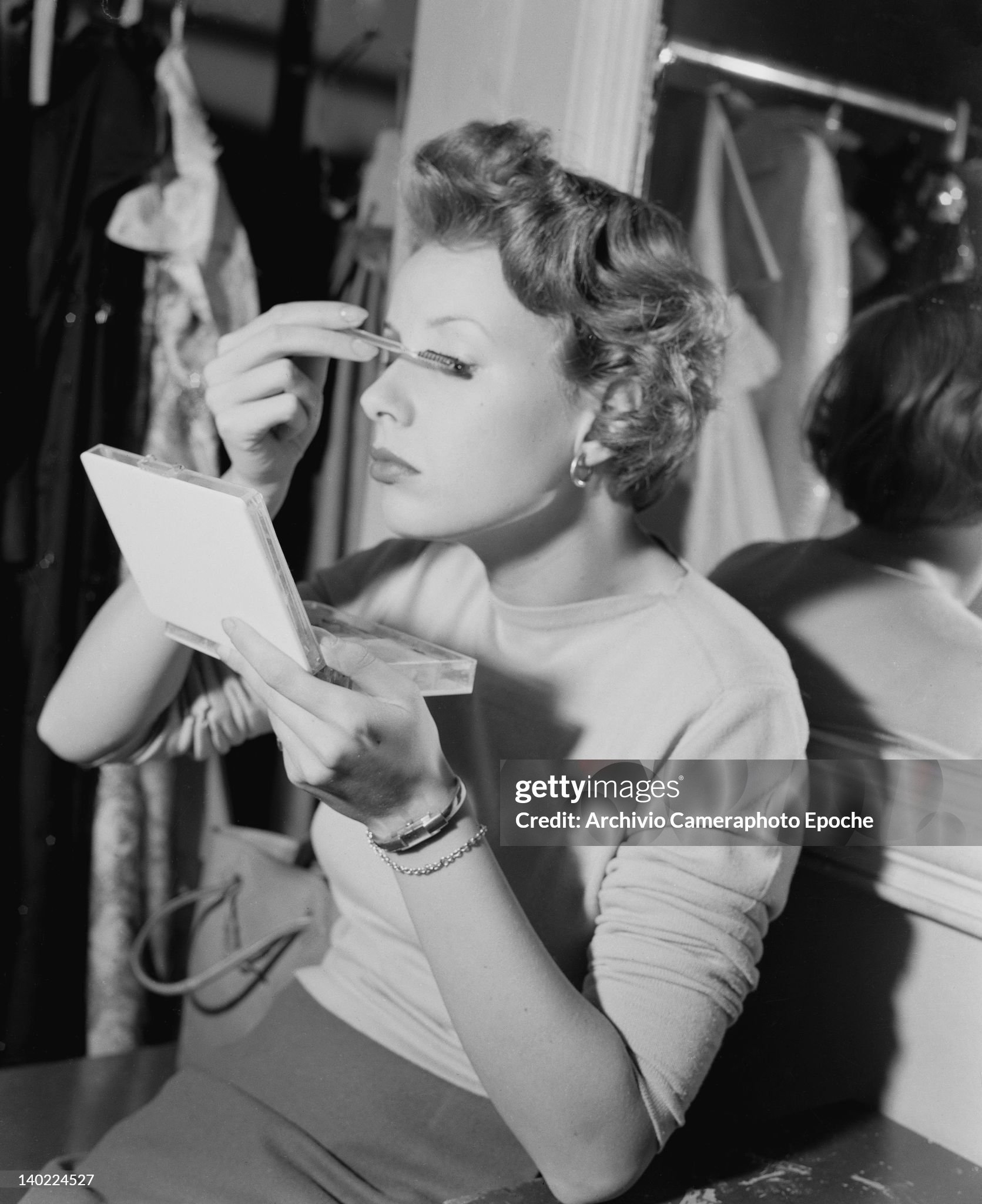A woman applies her make-up in Milan on 25 October 1949.