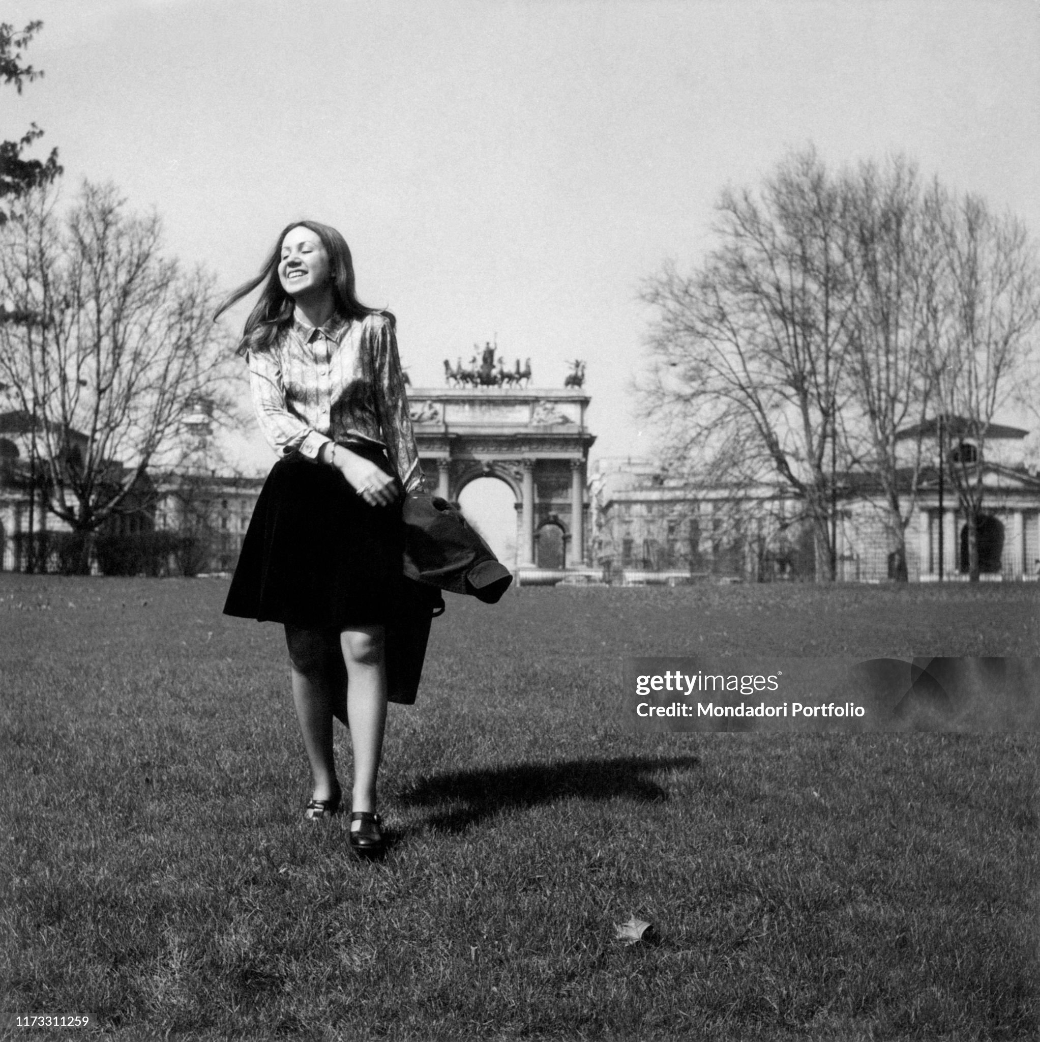 Silvia De Biasi, Mario De Biasi's daughter, young Italian girl, walking on the grass at Parco Sempione, close to the Arco della Pace, in Milan in 1956. 