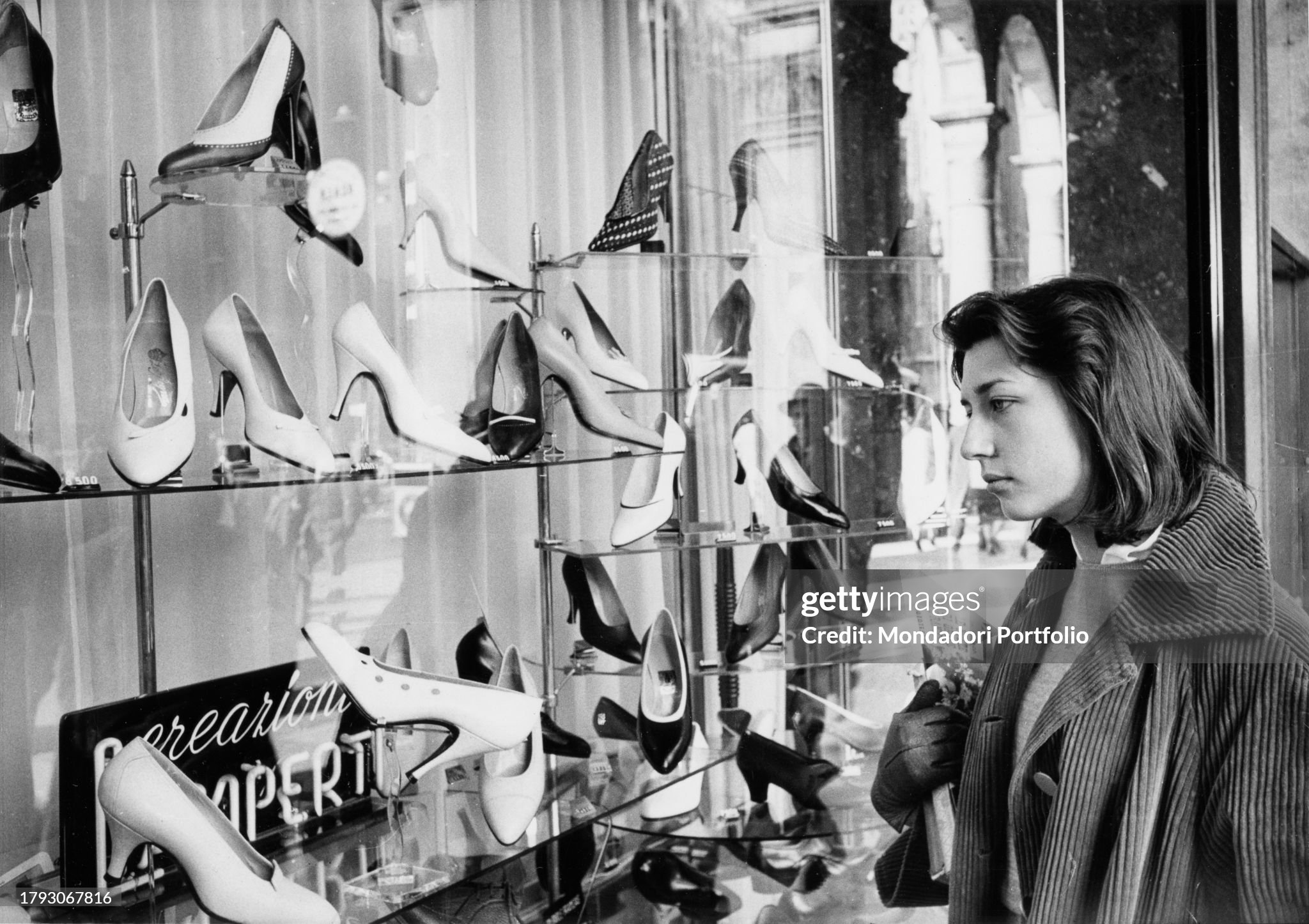 A young Milanese woman observes the window of a shoe store in Milan in 1956. 