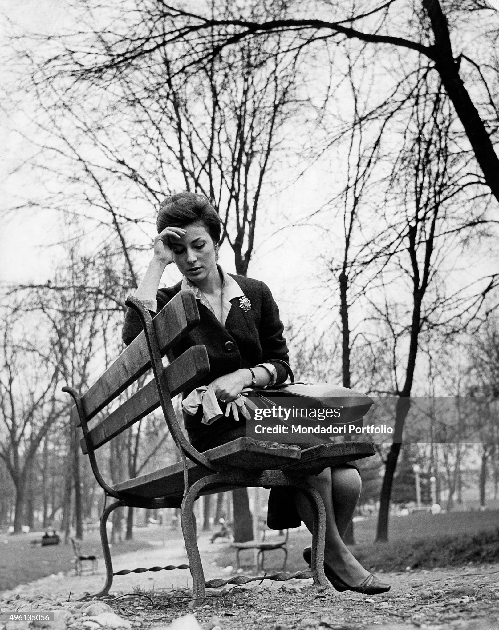 A woman, feeling dizzy, sitting on a bench in the Ravizza public park in Milan in April 1960. 