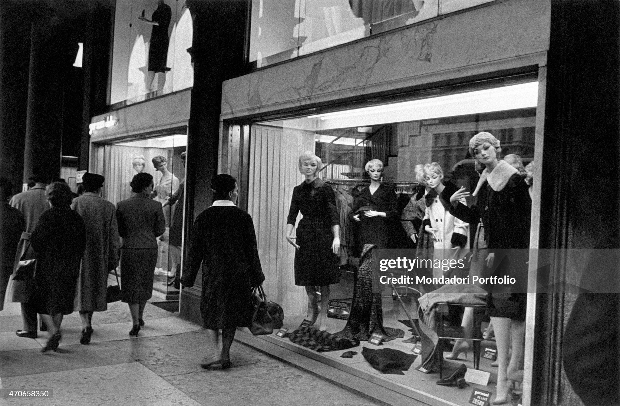 Women having a stroll catch a glimpse of the dummies exposed in a clothing store window display in Milan, Italy, in October 1960. 