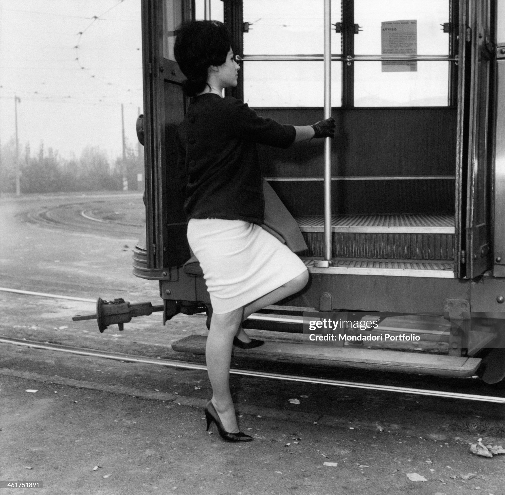 A young woman getting on the tram in Milan in 1960s. 