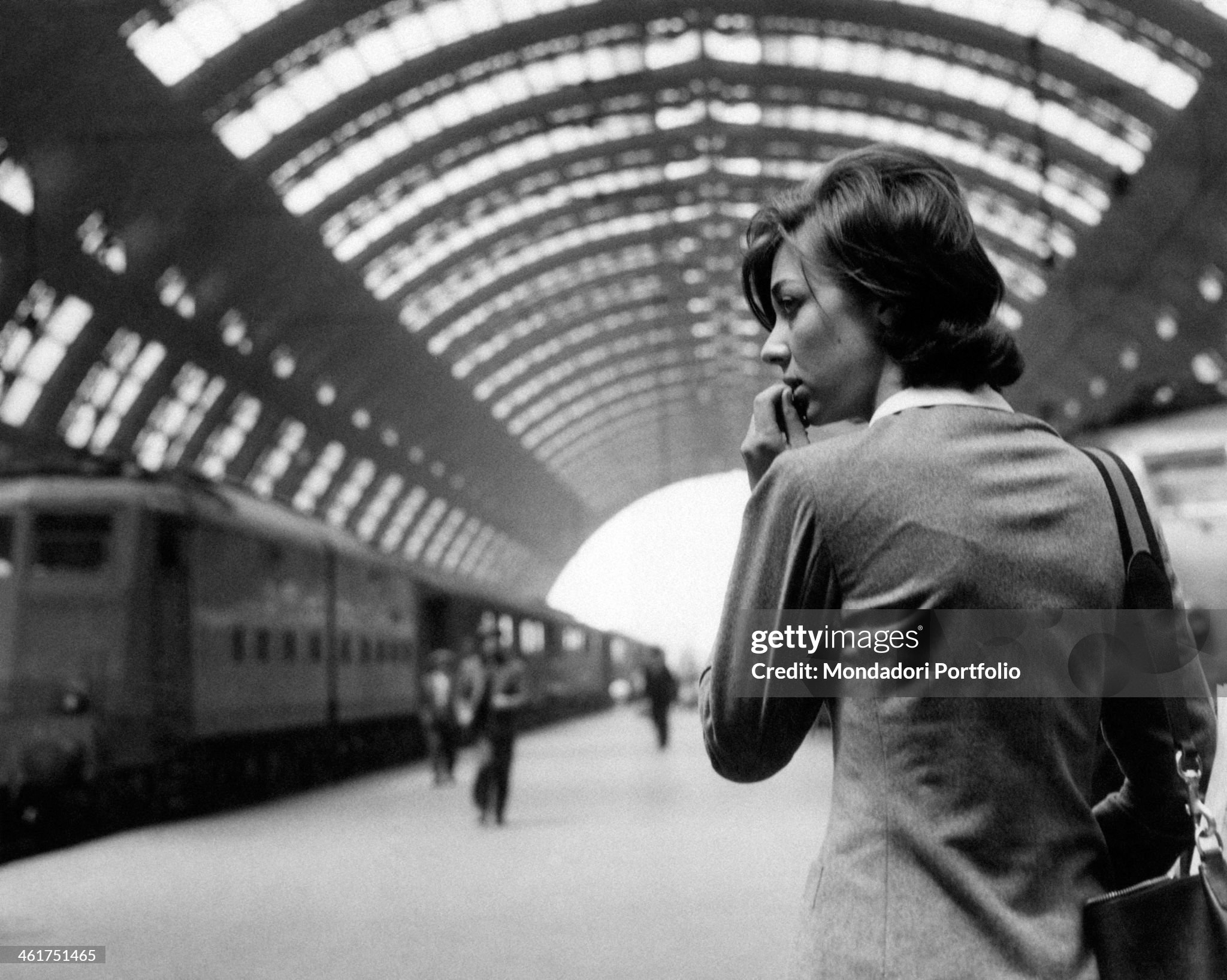 A young woman looking thoughtful on the platform at Milan Central Station in April 1961. 