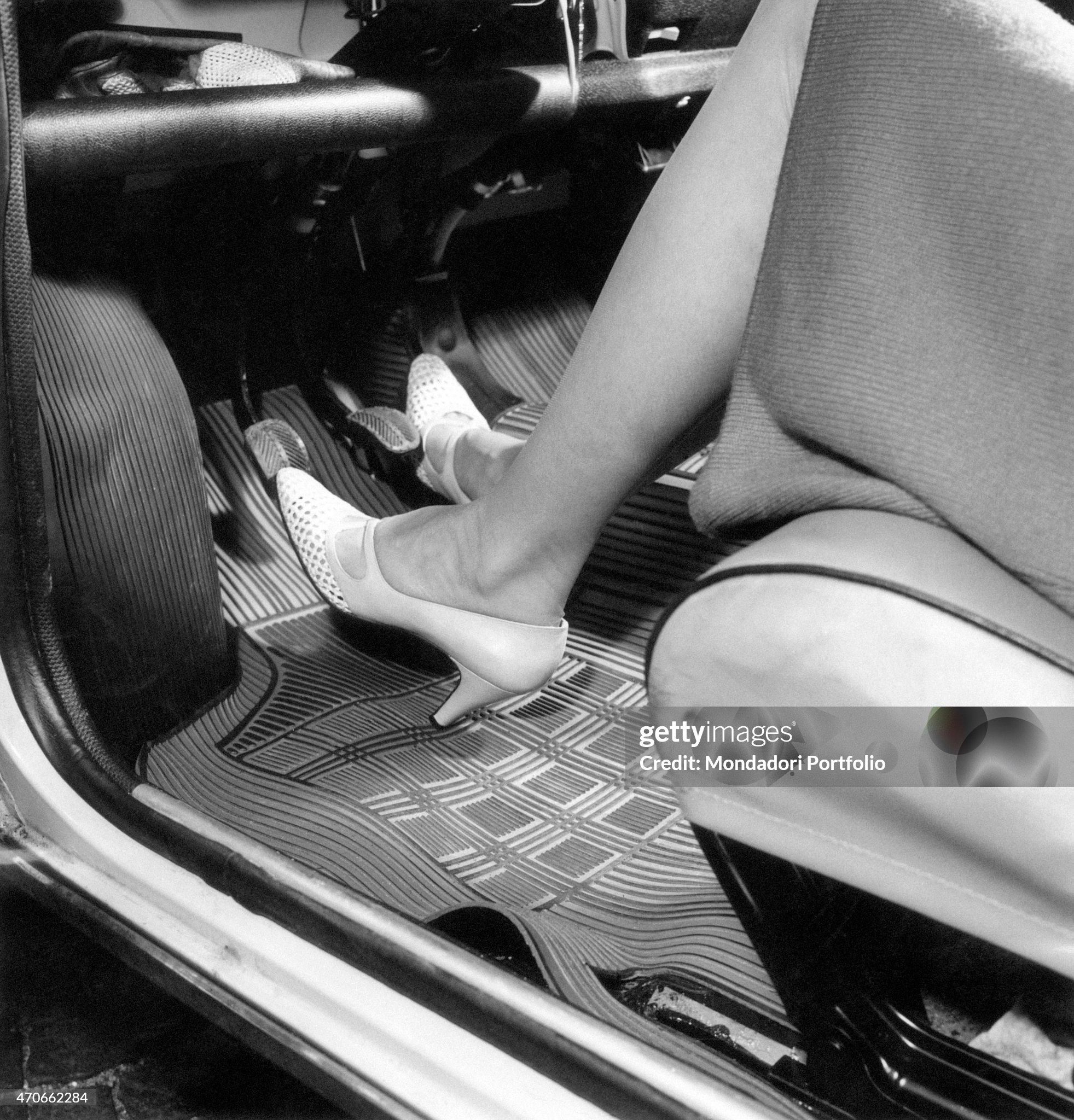 A woman activates the pedals of a car, while she practices driving in order to get her driving license in Milan on 20 April 1966. 