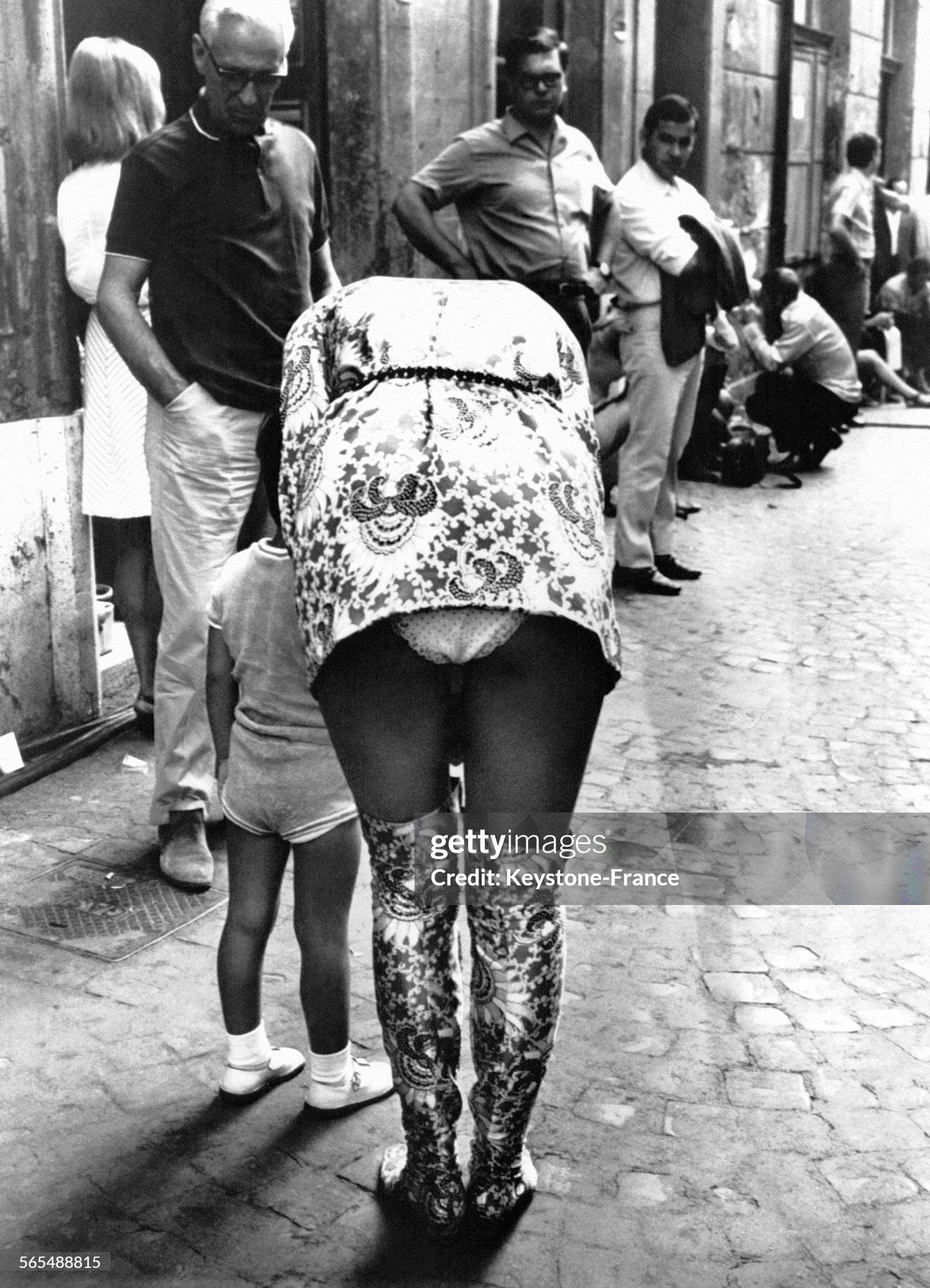 Young woman in a mini-skirt leaning towards her child in Milan, Italy, on 03 October 1968. 