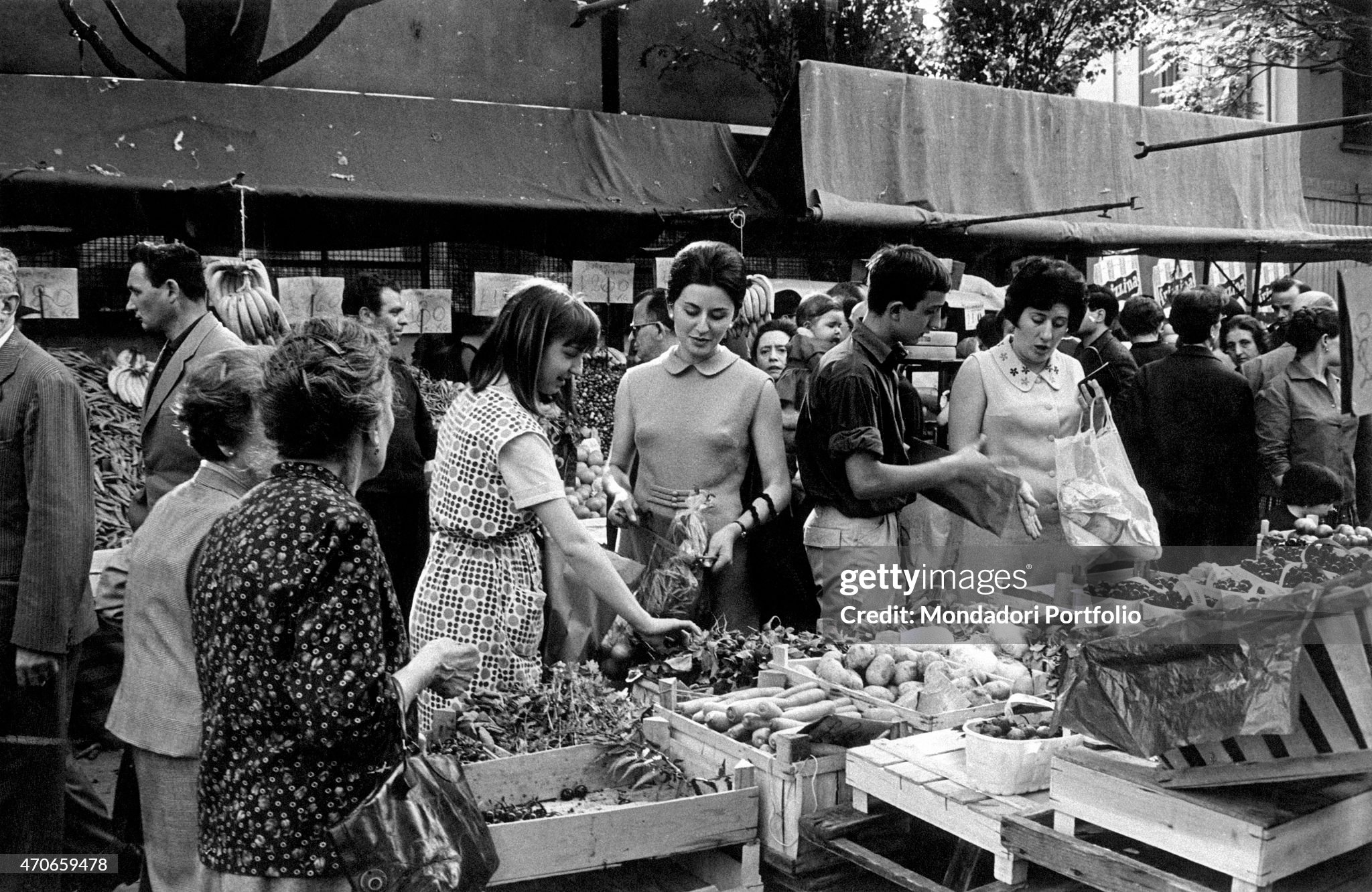 Some women choose fruits and vegetables from a stall in an open market place in Milan, Italy, on 04 December 1970. 