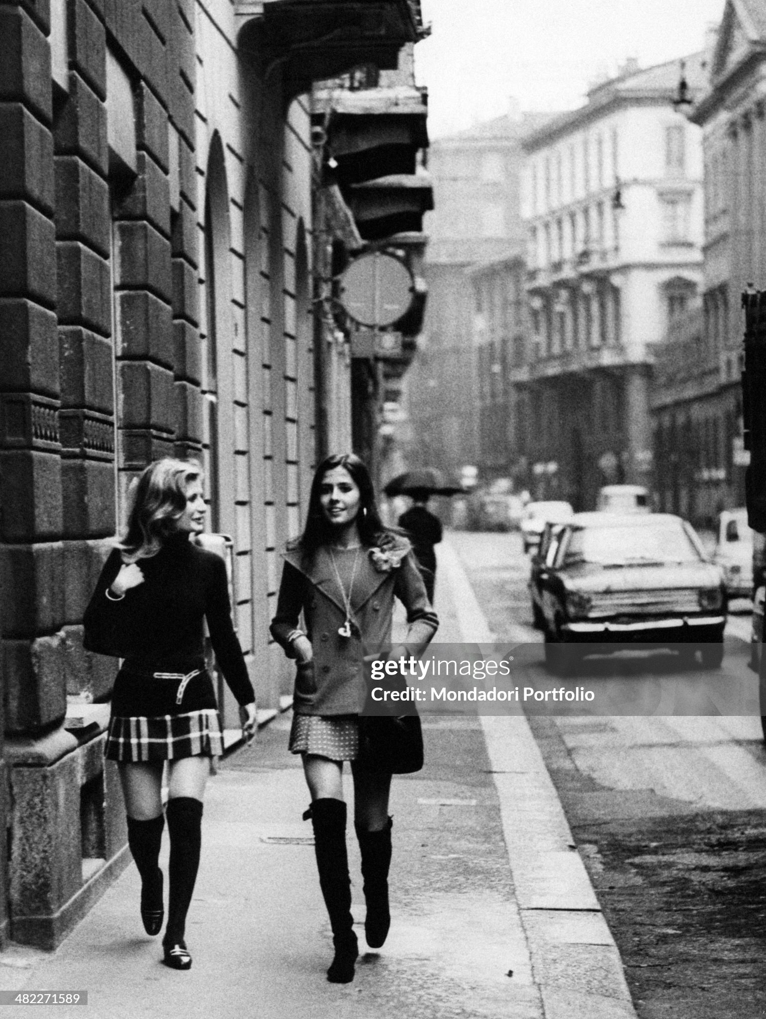 Two girls walking in a street of Milan in May 1971. 