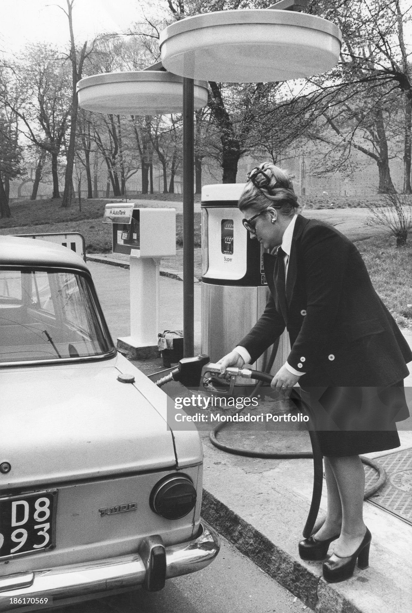 A woman refueling her car at a self-service gas station in Milan in 1973. 