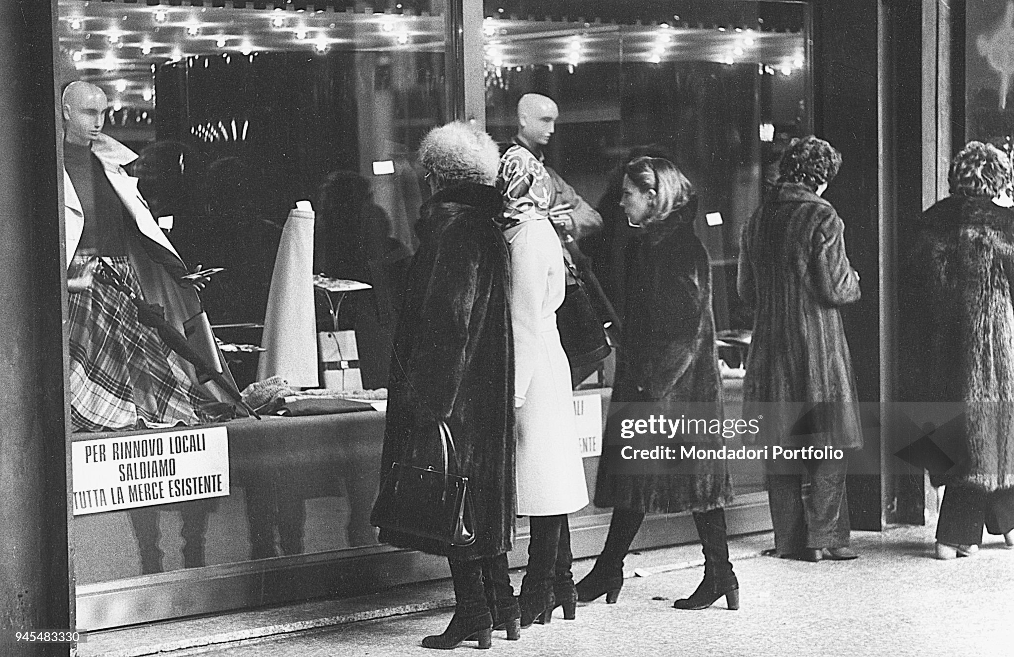 Women watching the window of a shop displaying goods on clearance sale in Milan in 1979.