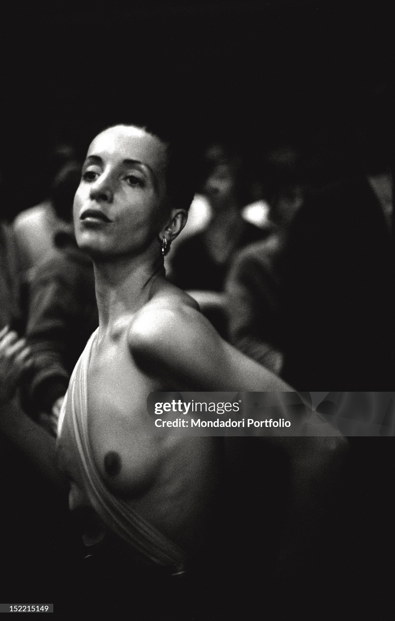 A girl is dancing on the dance floor at Studio 54 in Milan in 1979. Her dress, particularly sexy, uncovers her left breast. 