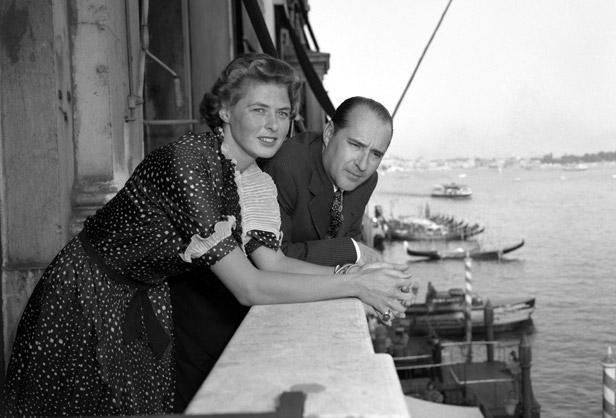 From a balcony of the Grand Hotel, Ingrid Bergman and Roberto Rossellini look at the world go by.