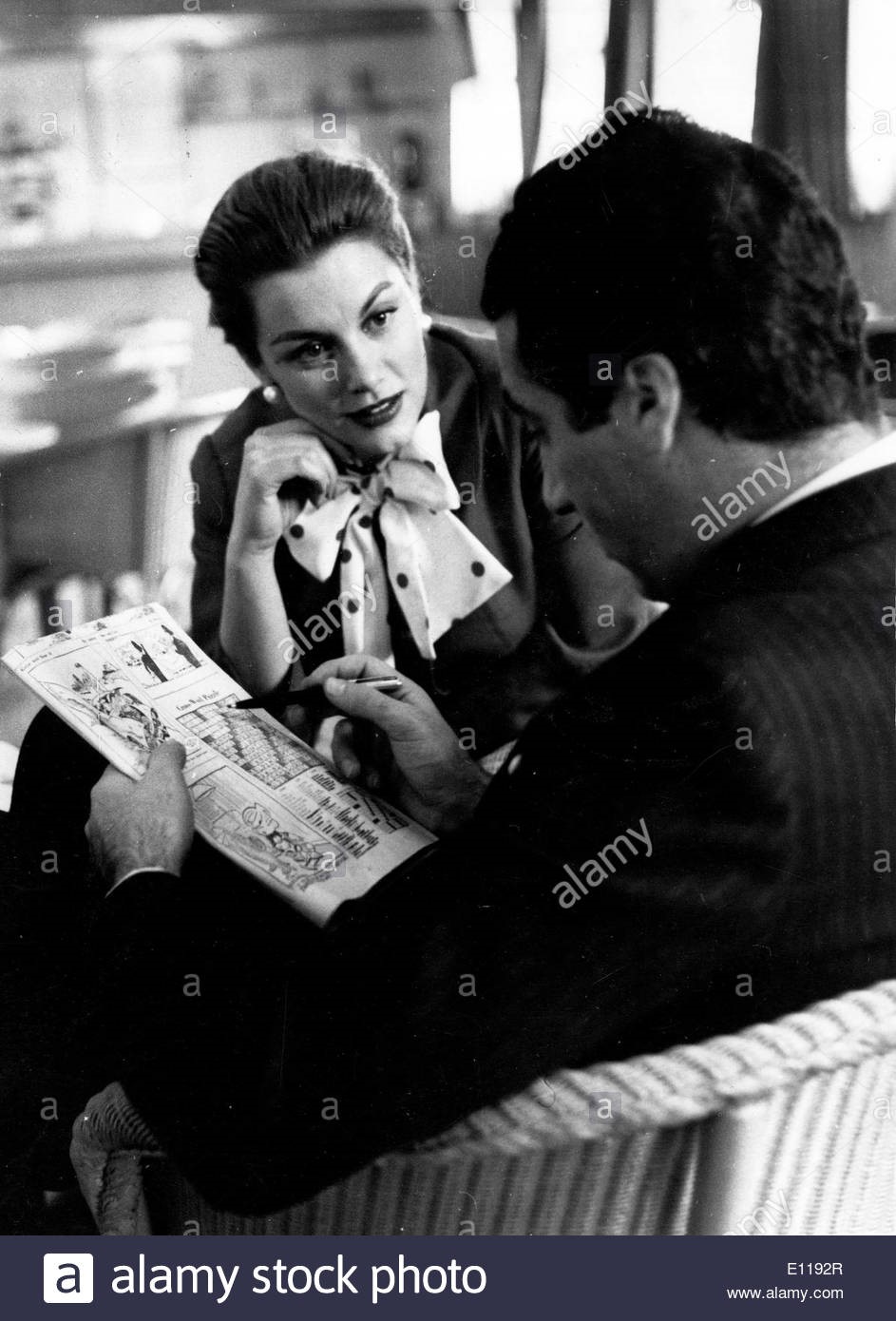 April 15, 1957, London, England, U.K. Actress Linda Christian and marquis de Portago do puzzles in the London airport while they wait for their flight. 