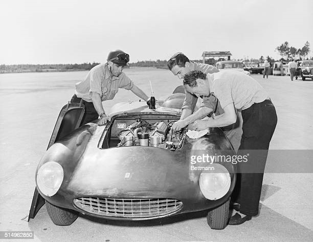 Spain's marquis de Portago (right) concentrates on the engine of his sleek Ferrari as mechanics Giannino Parravicini and Enzo Monari, both of Italy, make final repairs following a recent overhaul. Portago registered the fastest clocked time during warm ups for the Nassau road race, with 2:20 on the 3,1/2 mile runway course at Windsor Airfield.