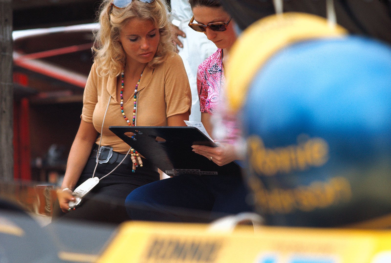 Barbro Peterson keeps her husband Ronnie's times (you can see Ronnie's helmet in the foreground) together with Siffert's wife Simone in the March pits during the German GP weekend in Hockenheim in August 1970. 